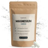 Een bruine papieren zak met het label "Cupplement Magnesium Complex" en twee witte capsules op de voorkant.