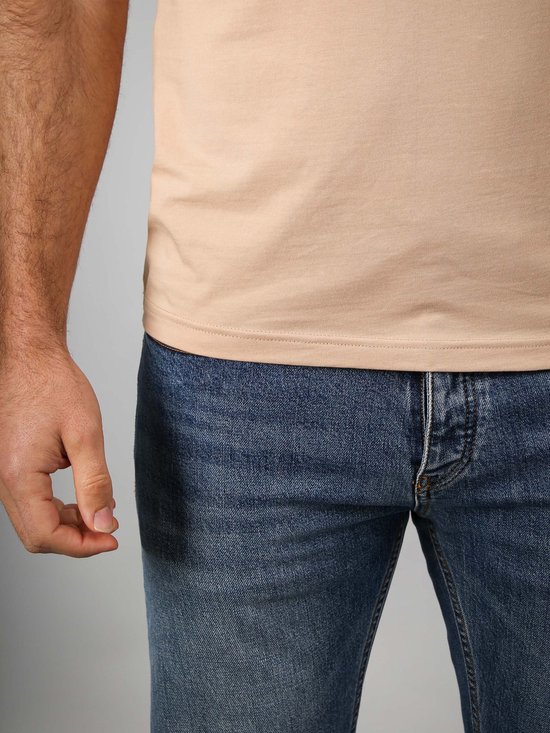 Sluiting van een beige v-hals t-shirt.