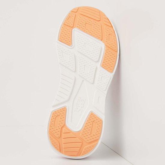 Onderkant van crème-kleurige sneaker met roze en oranje accenten op de zool.