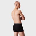 Man met een zwarte Calvin Klein boxer, van achteren gezien.