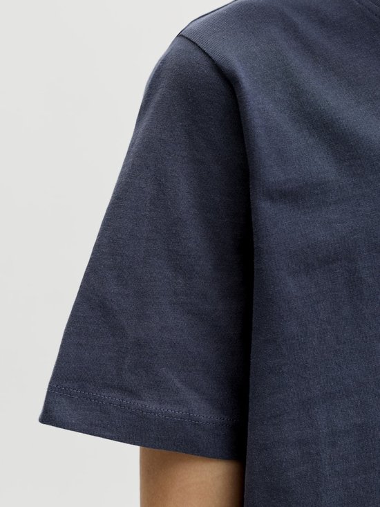 Detail van de donkerblauwe stof van een jongens T-shirt.