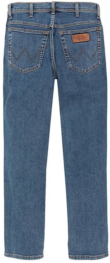 Achterkant van een blauwe spijkerbroek met een bruin Wrangler label op de rechterzak.
