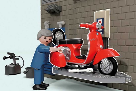 PLAYMOBIL monteur in blauw pak bij een rode Vespa scooter op een hefplateau.