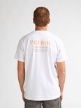Wit T-shirt met oranje opdruk op de rug: PETROL Industries, CUSTOM BUILT TO LAST & MADE TO ENDURE, BROUGHT TO YOU BY BY PETROL, Raceway.