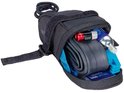 Zwarte zadeltas, open met reserveband, CO2-patroon, multitool en bandenlichters.