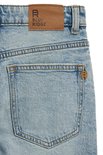 Detail van de achterkant van een lichtblauwe jeans met een bruin label 'BLUE RIDGE'.