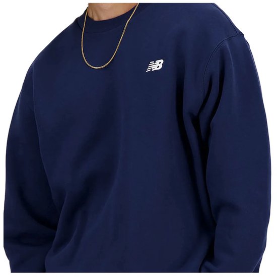 Close-up van donkerblauwe New Balance trui met wit logo op de borst.
