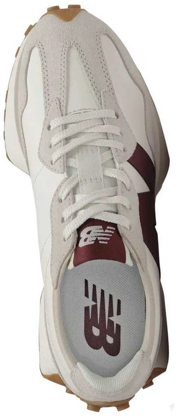 Witte New Balance sneaker met bruine accenten en noppen op de zool, van bovenaf gezien.