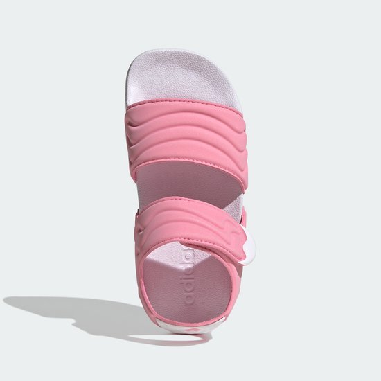 Roze Adilette sandalen voor kinderen met witte zool en geribbelde banden.