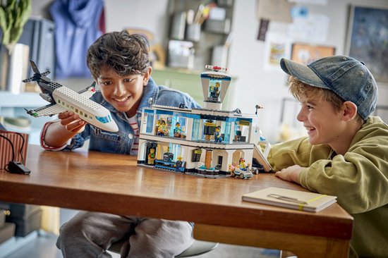 Twee jongens spelen met LEGO City Luchthaven met Vliegtuig (60502). Een jongen houdt het vliegtuig vast.