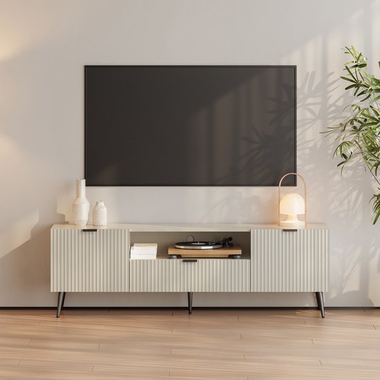 Crèmekleurig tv-meubel met geribbelde deuren en open vak, een tv hangt boven het meubel.