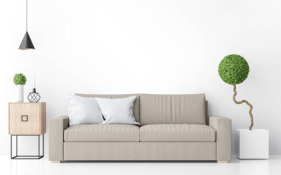 Lichtbeige tweepersoonsbank met twee witte kussens, naast een houten bijzettafel en een plant.