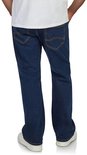 Achterkant van een man in donkerblauwe bootcut jeans met oranje stiksels en witte sneakers.
