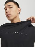 Model draagt een zwarte Jack & Jones t-shirt met witte tekst.