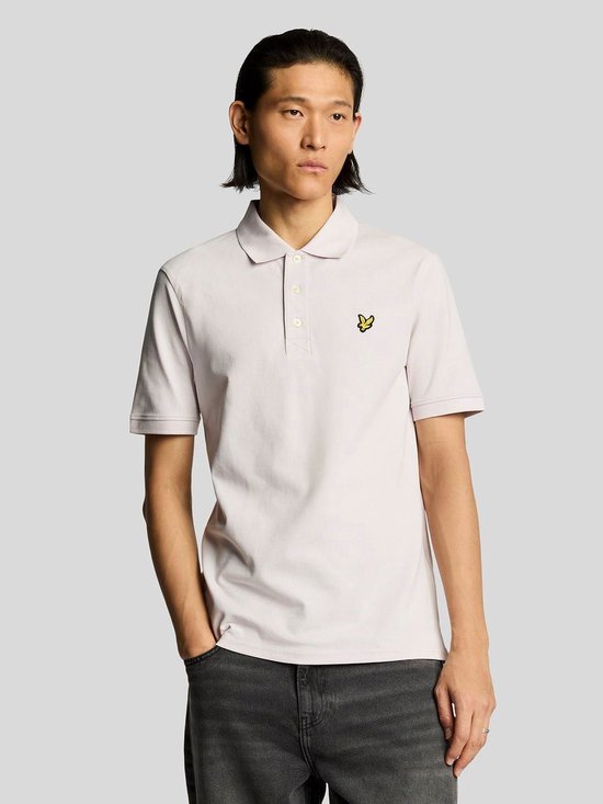 Man met lichtroze poloshirt, geel vogel-logo op de borst, witte knopen.