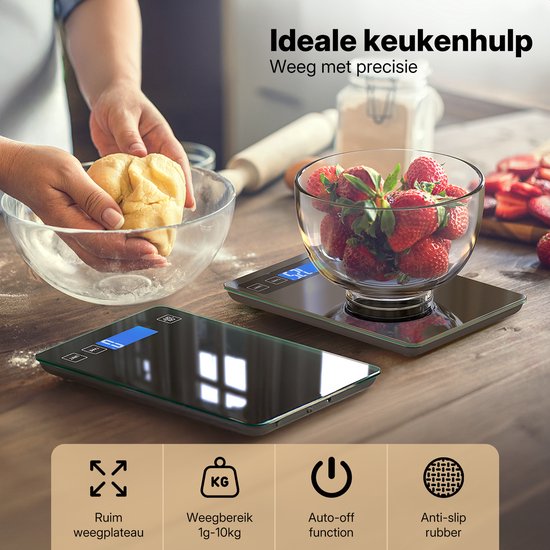 Balance de cuisine numérique noire avec surface brillante, sur table en bois, avec un bol de fraises.
