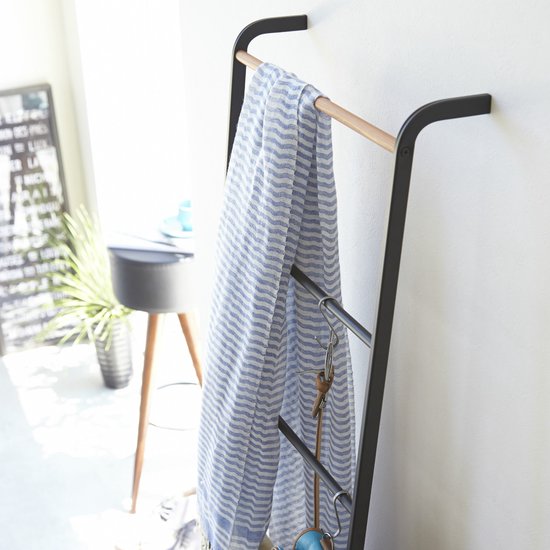 Zwarte ladder met houten dwarsbalk, met een blauw-wit gestreept textiel.