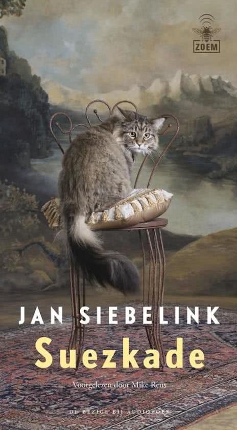 Un chat est assis sur une chaise avec un coussin, un tableau en arrière-plan.