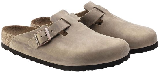 Een paar lichtgrijze Birkenstock Boston klompen met gespen, gemaakt van suède.