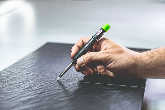 Hand met Pica-Dry markeerstift die een lijn tekent op een donker oppervlak.
