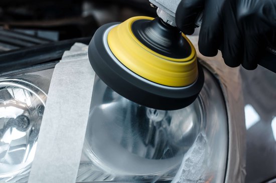 Machine die auto koplamp polijst. Gekkoppelde polijstschijf op een machine.
