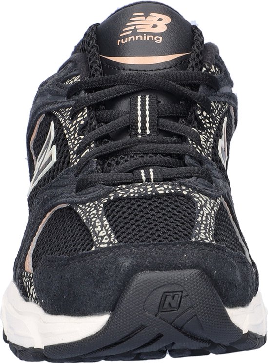 Voorkant zwarte New Balance sneaker, mesh met luipaardprint, beige logo.