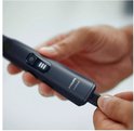 Hand die de batterij indicator toont van de Philips OneBlade Pro.