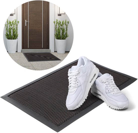 Donkere deurmat met honingraatpatroon en witte sneakers.