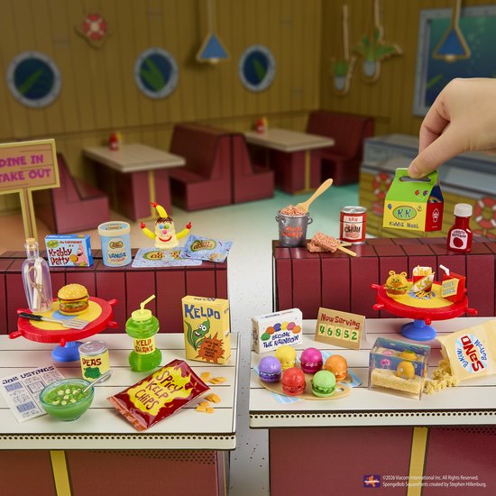 Mini Krabby Patty-burgers, Kiddie Meal, ketchup en mosterd op rode tafels met een 'Now Serving'-bord, macarons en een flesje met een brief.