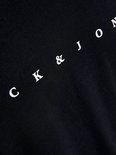 Detail van zwarte t-shirt met witte tekst "JACK & JONES" in een diagonale lijn.