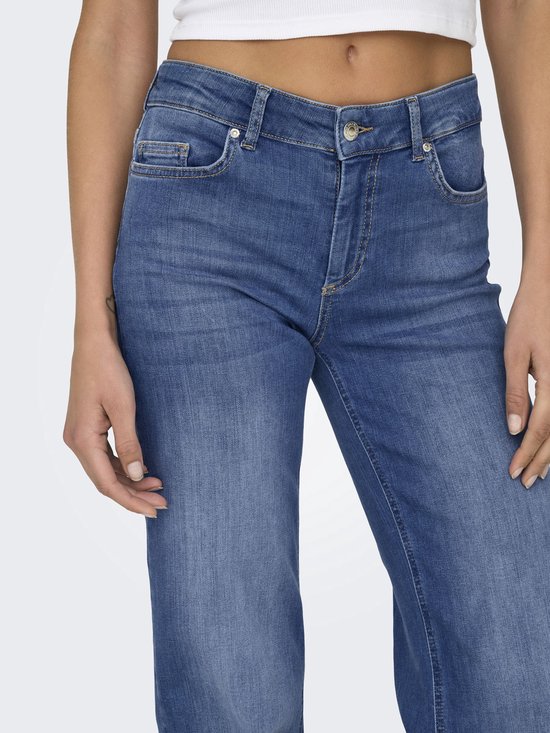 Close-up van een middelhoge jeans met rechte pijpen in medium denim met subtiele vervaging.