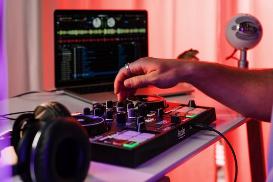 DJControl Inpulse 200 MK3 controller met verlichte pads, aangesloten op laptop. Hand bedient de jogwheel.