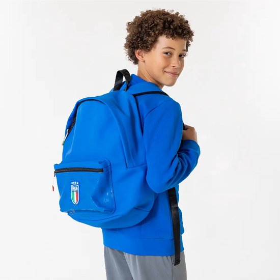 Jongen met blauwe rugzak met FIGC Italia-logo op de voorkant.