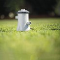 Grijze Intex Krystal Clear filterpomp, nat op gras, met waterdruppels.