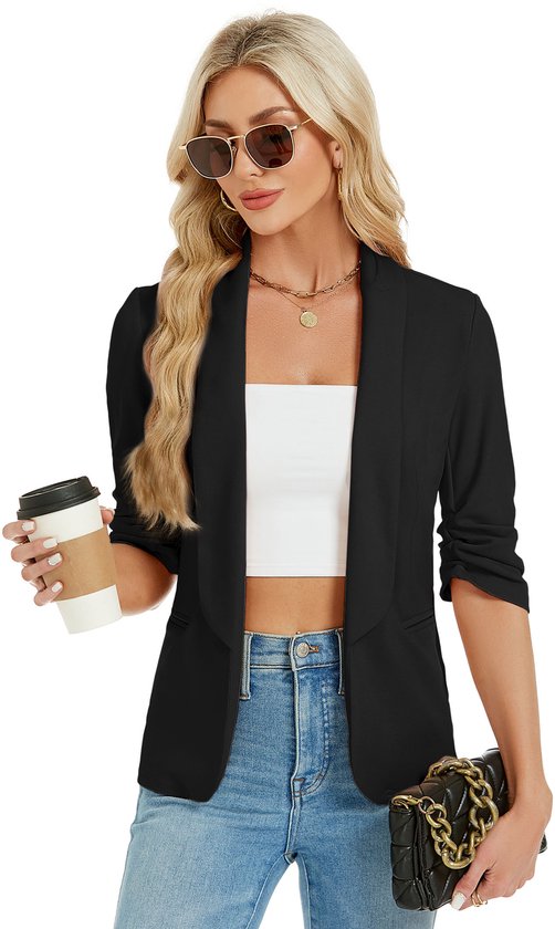 Zwarte blazer met opgestroopte mouwen, gedragen door blonde vrouw met witte top, spijkerbroek, zonnebril, kop koffie en handtas.
