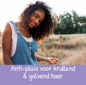 Model met lange, bruine, krullende haren lacht in de zon. Tekst "Anti-pluis voor krullend & golvend haar".