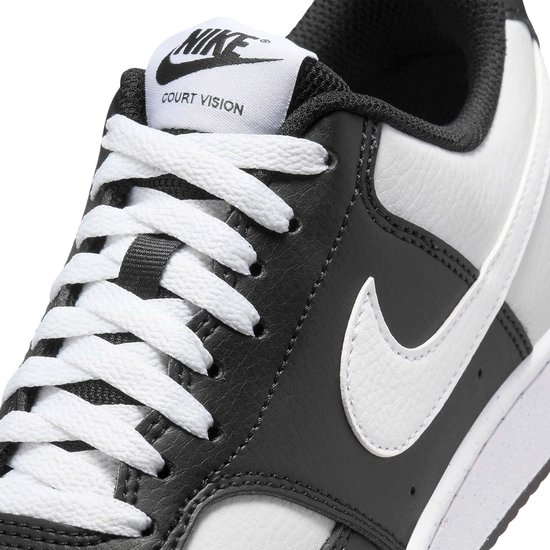 Close-up van de veters van een zwarte en witte Nike Court Vision Low sneaker.
