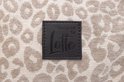 Leren label met 'Designed by Lotte' op een hondenmand met luipaardprint.