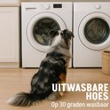 Australische herder zit voor wasmachines met tekst 'UITWASBARE HOES Op 30 graden wasbaar'.
