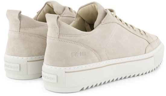 Crème suède lage sneakers, achterkant van de schoen, met beige veters en witte zool.
