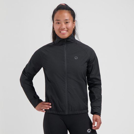 Modèle portant une veste de course noire Rogelli, col haut et fermeture éclair. Main sur la hanche.