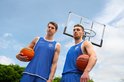 Twee basketbalspelers in blauwe tenues, elk met een oranje Virtufit basketbal.