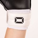 Detail van de witte klittenbandsluiting met zwart "ST" logo op de pols van een zwarte keepershandschoen.