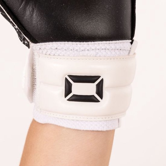 Detail van de witte klittenbandsluiting met zwart "ST" logo op de pols van een zwarte keepershandschoen.