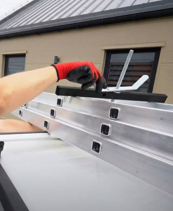 Hand met rode werkhandschoen bevestigt een ladder aan een dakdrager.