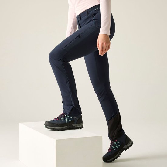 Donkerblauwe outdoorbroek met ritssluitingen aan de zijkant van de pijpen en versteviging bij de enkels.