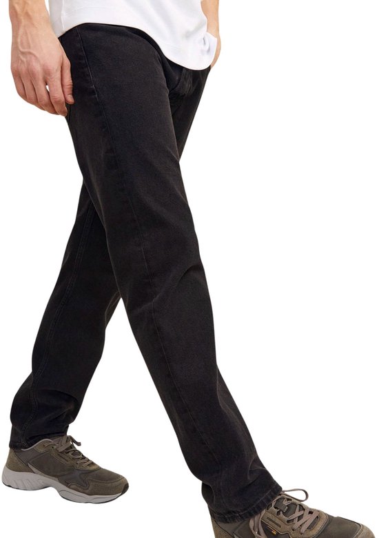 Man in Jack & Jones zwarte jeans en grijze sneakers