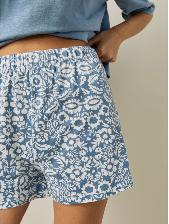 Korte blauwe pyjamabroek met witte bloemenprint, elastische tailleband.