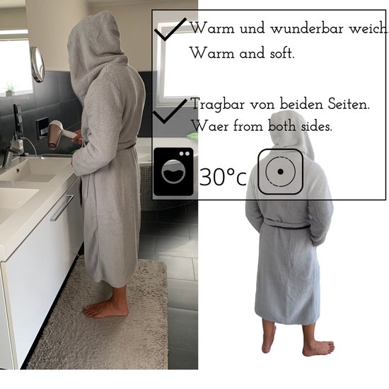 Homme portant un peignoir léger et réversible à capuche, debout près d'un lavabo.