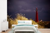 Behang - Fotobehang Een rode vuurtoren met een paarse hemel bij het eiland Schiermonnikoog - Breedte 450 cm x hoogte 300 cm